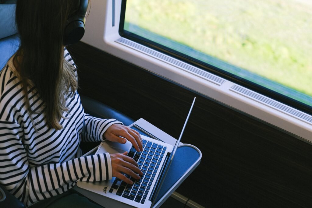 Person Wearing a Striped Long Sleeve Shirt inside a Train